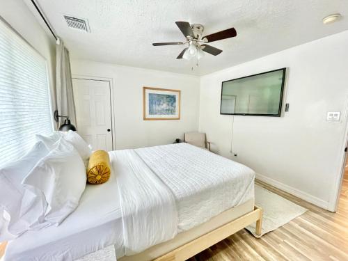 a white bedroom with a bed and a ceiling fan at Boho Chic in Humble