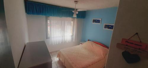 a small bedroom with a bed and a window at Apto 304 - 1 quadra do mar e centro in Capão da Canoa