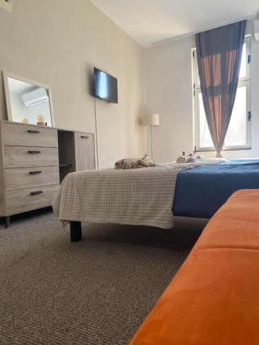 a bedroom with a bed and a dresser and a television at Stari Zaječar apartments in Zaječar