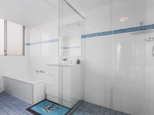 a white bathroom with a shower and a sink at Fairleigh Unit 1 in The Entrance