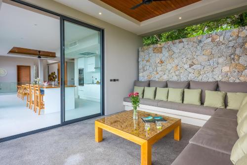 a living room with a couch and a table at Bay Villas Koh Phangan in Salad Beach