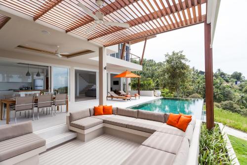 an outdoor living room with a couch and a pool at Bay Villas Koh Phangan in Salad Beach