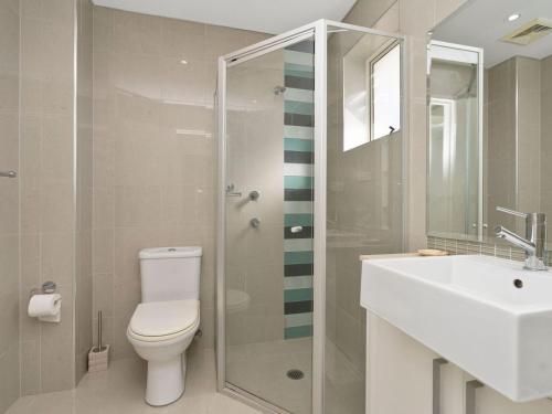 a bathroom with a toilet and a sink and a shower at Ocean Views Sundrift Unit 26 in The Entrance