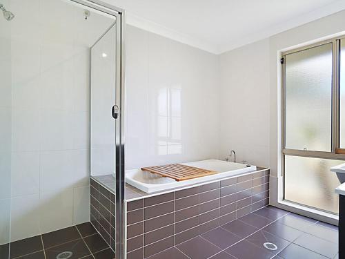 a bathroom with a shower and a bath tub at The Corso Gorokan in Gorokan