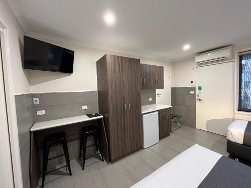 a small room with a kitchen and a bed at Ryley Motor Inn in Wangaratta