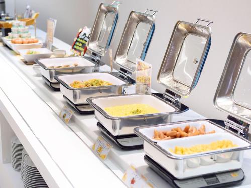 a row of trays of food on a counter at Hotel Abest Grande Okayama in Okayama