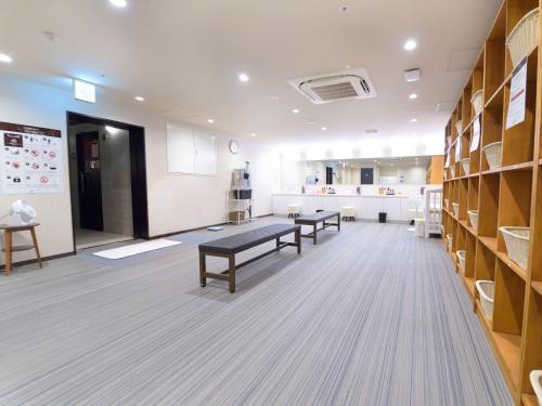 a room with two benches in a room with shelves at Hotel Abest Grande Okayama in Okayama