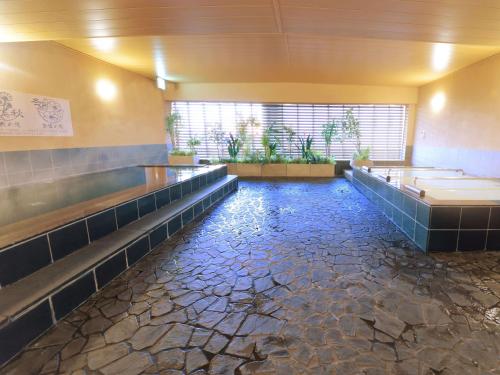 a bathroom with a pool of water in the floor at Hotel Abest Grande Okayama in Okayama