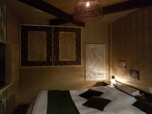 a bedroom with a bed with white sheets and black pillows at ホテルLambie in Tōgane