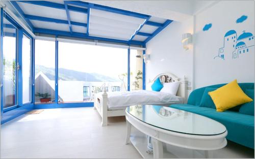 a blue and white bedroom with a bed and a glass table at Chiaohsi Mediterranean Spa B&B in Jiaoxi