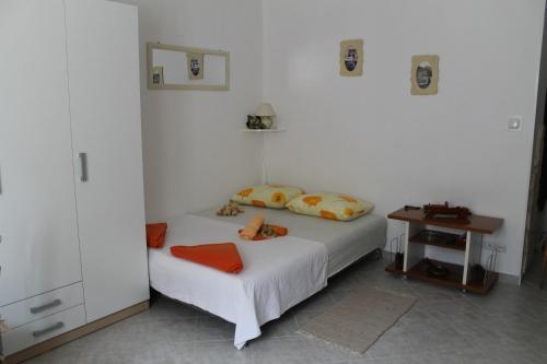 a white bedroom with a bed and a table at Apartment Devivi Adris in Split