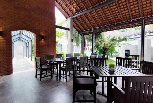 a restaurant with tables and chairs and a brick wall at R-Mar Resort and Spa Patong, Phuket in Patong Beach