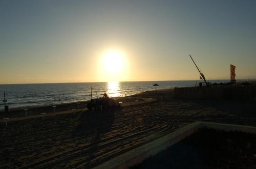 a sunset on the beach with the sun setting at Le Coin Vert in Fregene