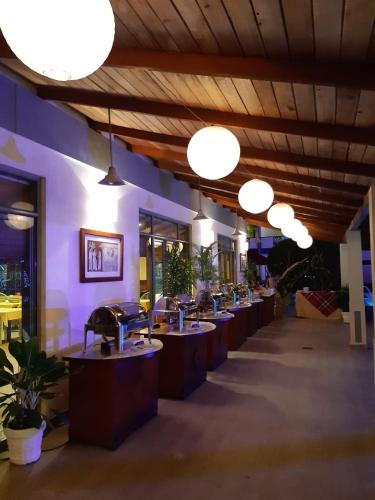 a row of tables in a room with lights at The Oasis Beach Resort in Hambantota