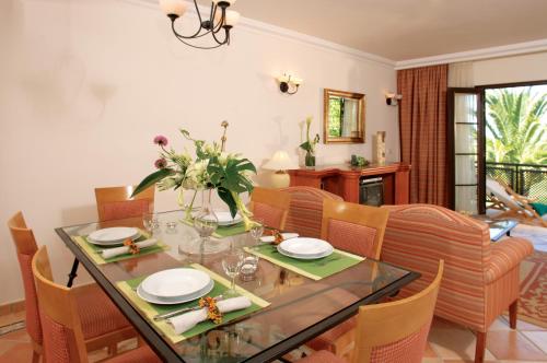 a dining room with a table and chairs at Pine Cliffs Village in Albufeira