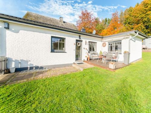 uma casa branca com um pátio e um quintal em Charming house with sauna and Nordic bath em Büllingen
