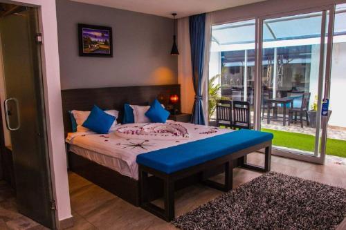 1 dormitorio con cama con banco azul y balcón en Good Time Boutique Hotel, en Sihanoukville