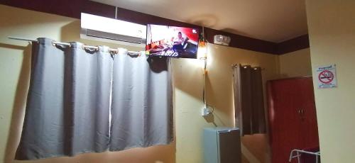a bathroom with a television and a shower curtain at บ้านสวนยายชุ่ม/bannsuanyaychum in Lampang