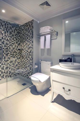 a bathroom with a toilet and a sink and a shower at Yan's House Hotel in Kuta