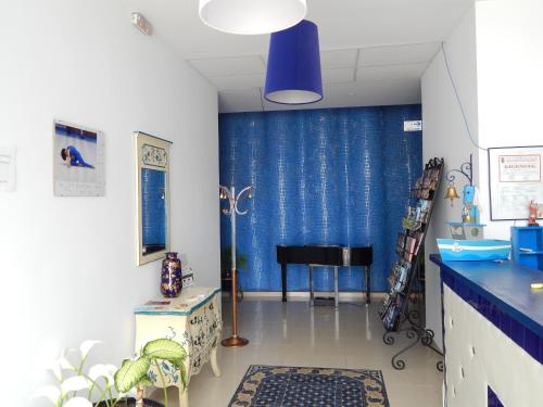 a living room with a blue curtain and a piano at Apartahotel Playa Conil in Conil de la Frontera