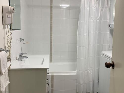 a white bathroom with a shower and a sink at Nesuto The Entrance Unit 409 in The Entrance