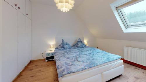 um quarto com uma cama com lençóis azuis e uma janela em Alte Schule Spittelstein 1OG rechts em Rödental