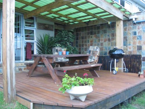 a wooden deck with a picnic table and a grill at Terryton Country Estate in Gonubie