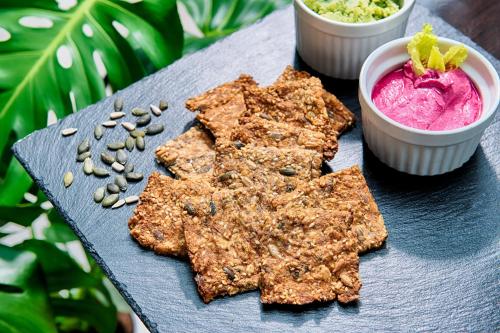 a plate of food with cookies and a pink dip at Hotel Carolinenhof in Berlin
