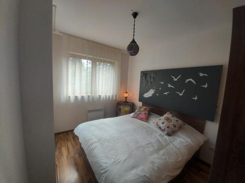 una camera con un letto bianco con due cuscini di 1 Bedroom cozy flat a Pamporovo