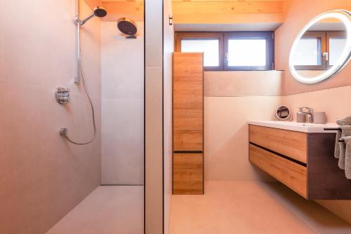 La salle de bains est pourvue d'une douche et d'un lavabo. dans l'établissement Fichtenlodge Stubaital, à Neustift im Stubaital