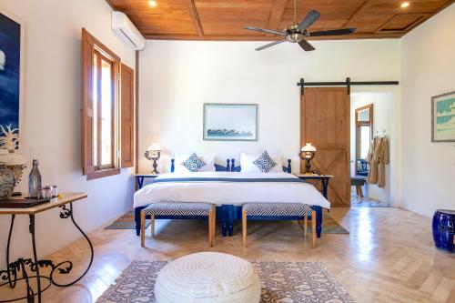 a bedroom with a large bed and two chairs at Villa Pulau Cinta Boutique Suites in Gili Meno