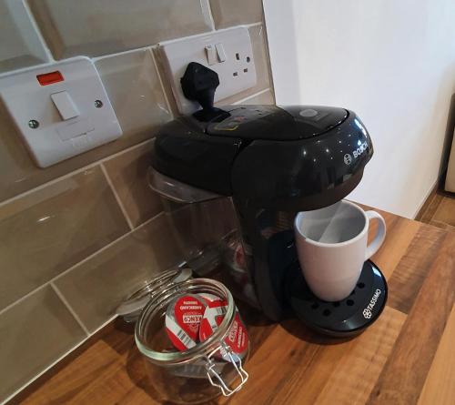 a coffee maker sitting on a counter with a cup at Milltate House Apartments in Irvinestown
