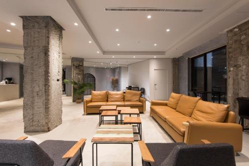 a lobby with couches and tables in a building at Sparrow Hotel in Taichung