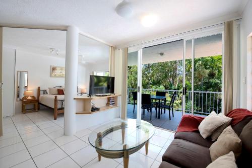 a living room with a couch and a glass table at Golden Sands Beachfront Resort in Yorkeys Knob