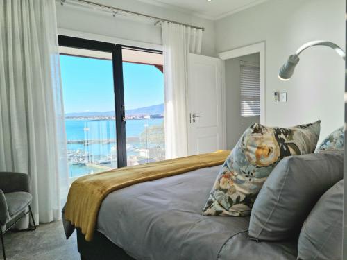 a bedroom with a bed with a view of the ocean at The Anchor, Luxury living for 2 with sea view and Jacuzzi in Gordonʼs Bay