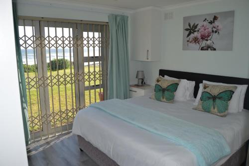 a bedroom with a large bed and a balcony at Hermanus Beach Club - Le Maree House 18 in Hermanus