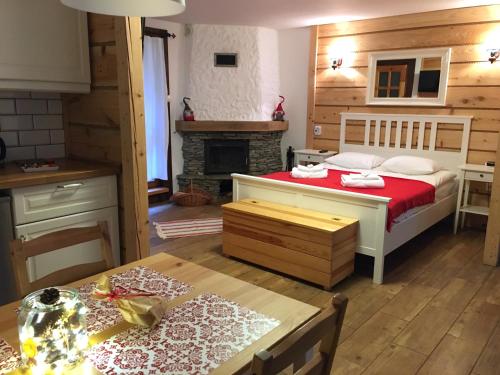 a kitchen and a bedroom with a bed and a fireplace at 3pokoje - Domek lub Pokój pod lasem na odludziu, jacuzzi, sauna, kominek, Roztocze in Susiec