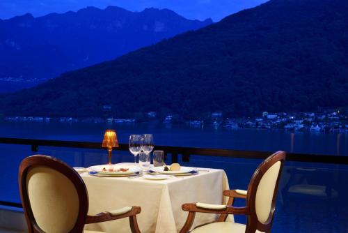 a table with two chairs and a table with wine glasses at Swiss Diamond Hotel & Spa in Morcote
