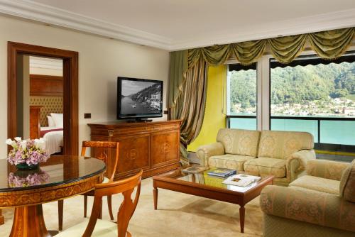 a living room with a couch a table and a television at Swiss Diamond Hotel & Spa in Morcote