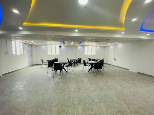 Una gran sala con mesas y sillas. en Avi Fortune Suites - Near Bangalore International Airport, en Bangalore