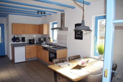 a kitchen with a wooden table and a dining room at Ferienhaus am Yachthafen in Sellin