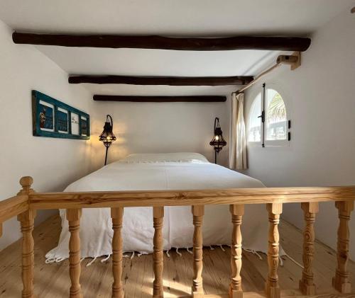 a bedroom with a white bed and white walls at Riad Baladin in Essaouira