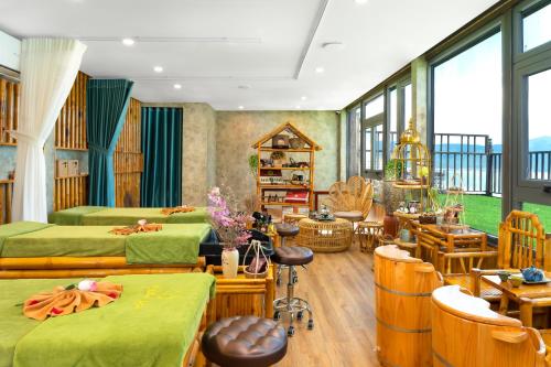 a bedroom with two beds and a room with chairs at Halina Hotel and Apartment in Da Nang