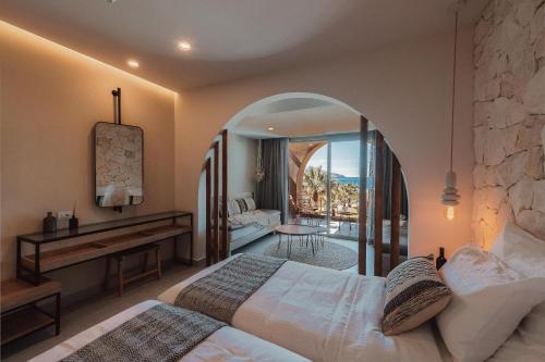 a bedroom with a bed and a desk in a room at Eliros Mare Beachfront Poem Hotel in Georgioupolis