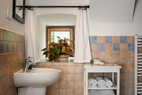 een badkamer met een wastafel, een toilet en een spiegel bij Penzion Oloffson in Počátky