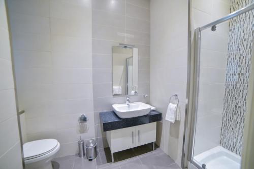 a bathroom with a sink and a toilet and a shower at CA1- City Central Apartment 1 in Valletta