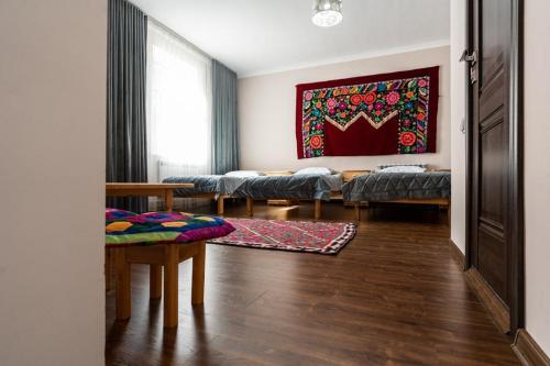 a living room with beds and a painting on the wall at Muras Hotel Karakol in Karakol