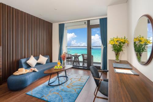 a living room with a blue couch and a table at Canvas Danang Beach Hotel in Da Nang