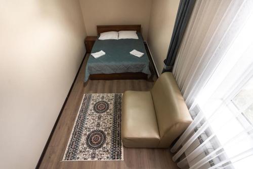 a small room with a bed and a couch at Muras Hotel Karakol in Karakol