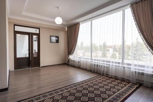 a large room with a large window and a floor to ceiling at Muras Hotel Karakol in Karakol